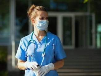modern physician woman in uniform outdoors near clinic