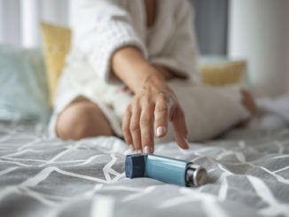 Asmathic girl catching inhaler having an asthma attack