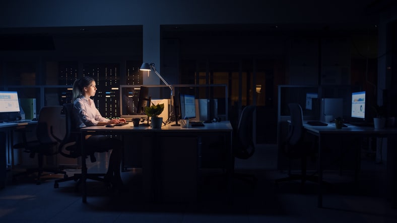 Working Late at Night in the Office: Businesswoman Uses Desktop Computer, Analyzing, Using Documents, Solving Problems, Finishing Important Project. Diligent Ambitious Young Worker. Side View
