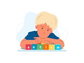 Close up portrait of toddler autistic boy with word AUTISM on wooden blocks
