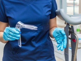 Gynecologist holding a gynecological speculum with gloves