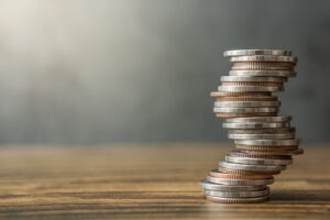 Stack of coins on wood desks and loft wall backgrounds with sunlight