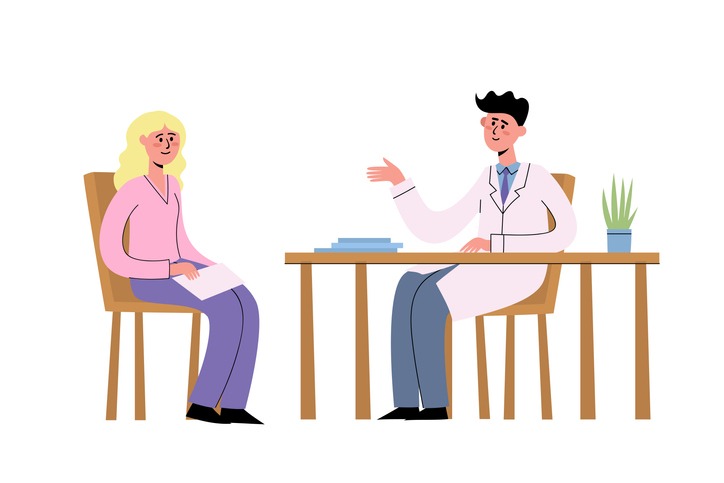 doctor at table talking with woman patient