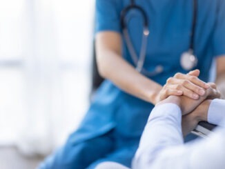 Cropped shot of a female nurse hold her senior patient’s hand. Giving Support. Doctor helping old patient with Alzheimer’s disease. Female carer holding hands of senior man