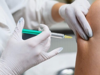 Doctor apply syringe needle in female hand