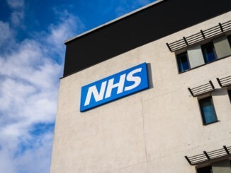 View of a NHS (National Health Service) logo on the outside of a building