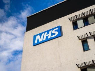 Image of hospital building with NHS sign outside