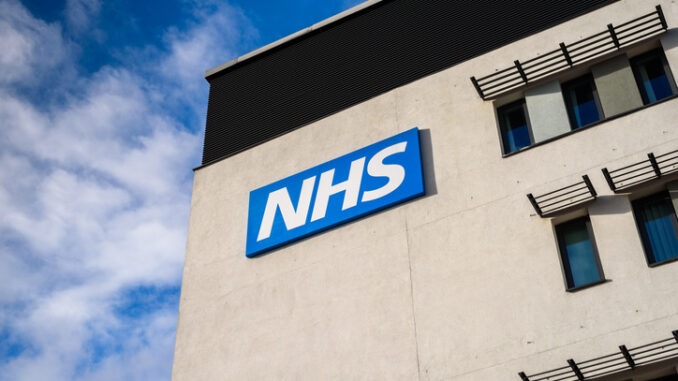 Image of hospital building with NHS sign outside