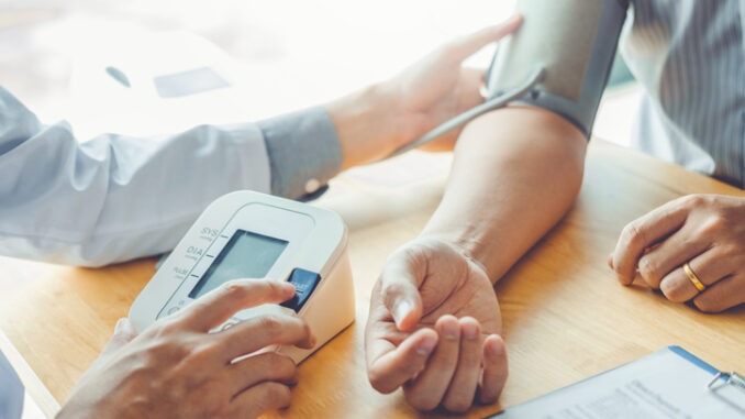 Doctor Measuring arterial blood pressure with man patient on arm Health care in hospital