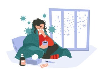 Disease. The girl has a cold, sits wrapped in a blanket, with a handkerchief and a mug of tea.