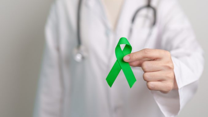 Doctor with green Ribbon for world Mental Health Day, Liver, Gallbladders, bile duct, cervical, kidney Cancer and Lymphoma Awareness month. Healthcare and world cancer day concept