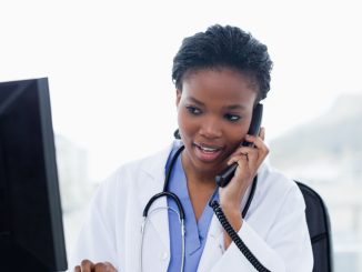 Female doctor on the phone while using a computer in her office