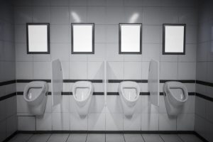 Empty advertisement frames in public toilet for men