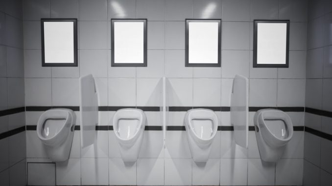 Empty advertisement frames in public toilet for men