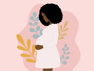 Side View Of Young Pregnant African Woman With Black Curly Hair Holding Her Belly. Pregnancy And Motherhood Concept With Pregnant Woman And Leaves On Pink Background