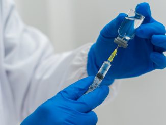 Doctor hand holding a syringe and drawing vaccine from a vial