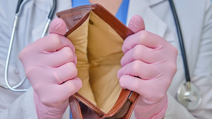 A doctor in medical gloves shows an empty wallet. 