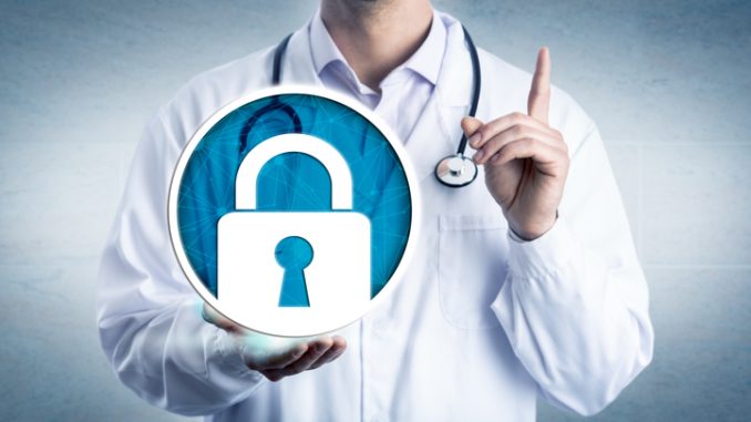 data security in health care by holding a locked padlock icon. Information technology and healthcare metaphor for cybersecurity, privacy, secure health records.