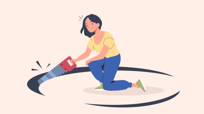 Self sabotage. Woman with saw sawing hole in floor