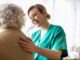 Friendly nurse supporting an elderly lady