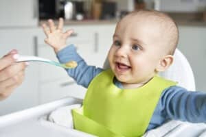 Picture of a baby looking happily at some food.