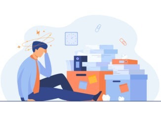 Tired man sitting on floor with paper document piles