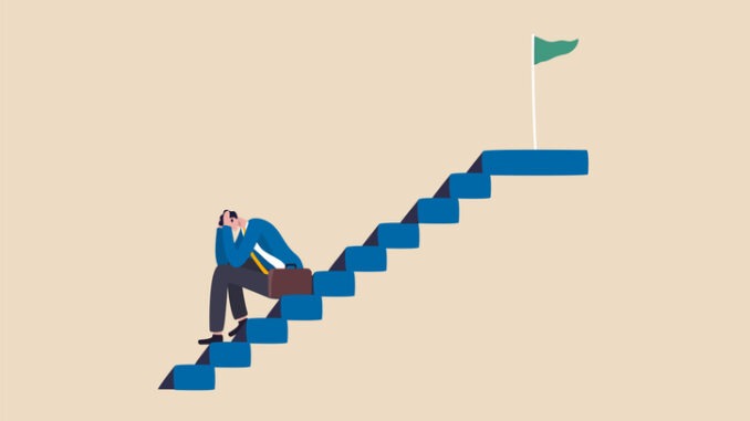 depressed businessman sitting alone on stairway to success goal.