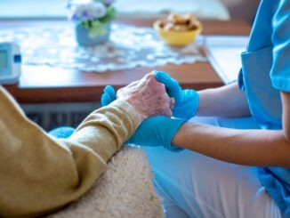Young female doctor is holding her patient's hand, comforting her. Old lady is worried and doctor is there to take care of her every need. Old lady is in trusting hands.