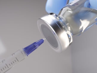 Syringe being inserted into a vaccine vial.