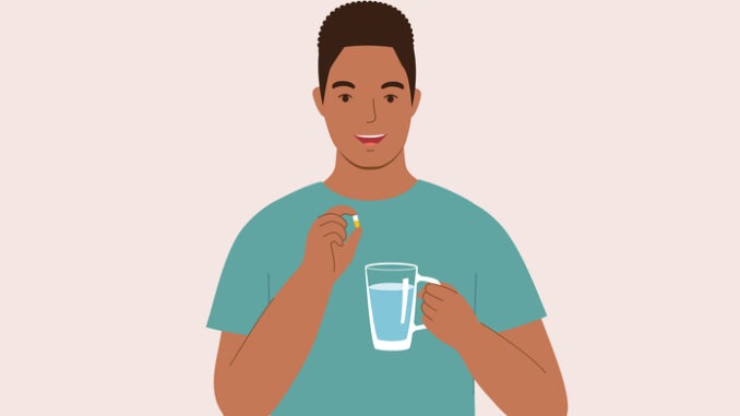 One Smiling Man Taking Pill With A Glass Of Water.