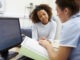 Nurse Discussing Test Results With Patient In Office Looking At Documents