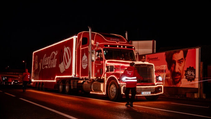 Coca Cola Christmas Truck Tour showcases a vibrant red truck adorned with lights on a city street, enhancing the holiday spirit