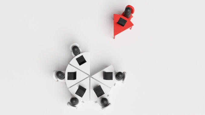 Group of office employees working at a round pie chart shaped table with a single desk being isolated. Illustration of the concept of workplace bullying and lack of teamwork