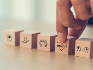 Empathy concept. Wooden blocks with empathy icons on minimal background and copy space. The power of emotional intelligent, soft skill development. Empathy in the workplace, good leaders, good teams.