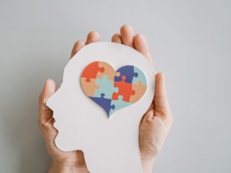 Hands holding jigsaw puzzle heart shape in brain Autism awareness, neurodiversity concept, World Autism Awareness Day