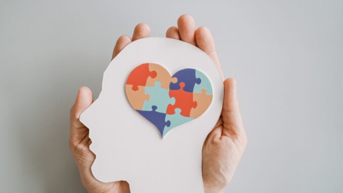 Hands holding jigsaw puzzle heart shape in brain Autism awareness, neurodiversity concept, World Autism Awareness Day
