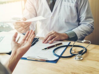 Doctor or physician writing diagnosis and giving a medical prescription to female Patient