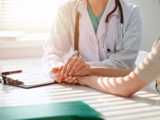 Doctor and patient are discussing something in clinic, just hands at the desk. Medicine and best service concept.