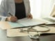 stethoscope and electrocardiogram on medicine report with doctor woman notes information patient medical history at the hospital.