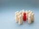 A socially diverse person being surrounded and protected by a crowd of people for being different. Alternatively a Manager or boss at a pep rally being surrounded by workers and team mates