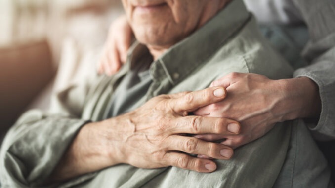 Comforting hand supporting the old man