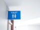 Typical male and female toilet sign seen in a typical British hospital. The background leads to various wards within the hospital. Used by both staff, visitors and patients.