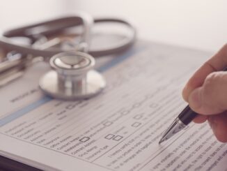 closeup pen in hand's doctor notes data on medical document.