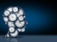 Time thinking concept as a group of clock objects shaped as a human head as a business punctuality and appointment stress metaphor or deadline pressure and overtime icon as a 3D illustration on a black background.