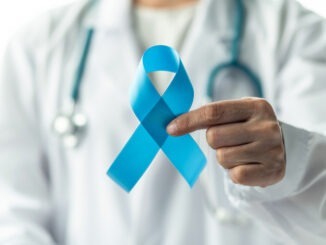Prostate cancer blue awareness ribbon for men health in November with light blue bow color on medical doctorâs hand in clinical lab gown in hospital, male patient healthcare concept