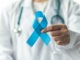 Prostate cancer blue awareness ribbon for men health in November with light blue bow color on medical doctorâs hand in clinical lab gown in hospital, male patient healthcare concept